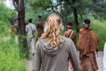 Turistas em uma trilha a pé com membros do povo San, homens do mato em Botswana — Fotografia de Stock
