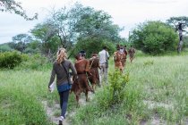 Tourists on a walking trail with members of the San people, bushmen. — Stock Photo
