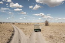Un vehículo de safari en una bifurcación en las vías por delante en campo abierto. - foto de stock