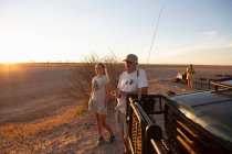 Grandfather and granddaughter looking out at sunset in the Kalahari Desert — Stock Photo