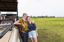 Madre con hija adolescente cerca de vehículo safari, Botswana - foto de stock