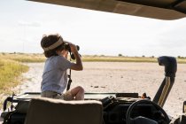 Ein sechsjähriger Junge blickt durch ein Fernglas über eine Salzpfanne — Stockfoto