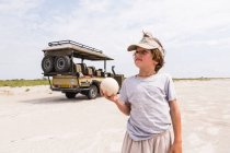 Boy holding up a large ostrich egg — Stock Photo
