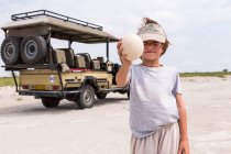 Boy holding up a large ostrich egg — Stock Photo