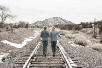 Preteen girls friends walking railroad tracks together, NM. — Stock Photo
