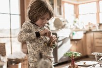 4-летний мальчик в пижаме играет с игрушками дома — стоковое фото