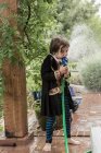 Young boy dressed as a pirate drinking from water hose — Stock Photo