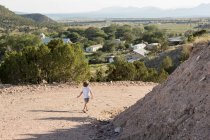 Niño de cuatro años haciendo senderismo en un paisaje rural - foto de stock