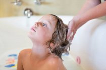 4 anno vecchio ragazzo avendo un bagno e shampoo in vasca da bagno — Foto stock