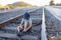 4-летний мальчик, сидящий на железнодорожных путях, Лами, шт. Нью-Мексико — стоковое фото