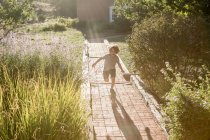 4 year old boy running on brick path — Stock Photo