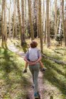 Visão traseira de crianças caminhando na trilha da natureza — Fotografia de Stock