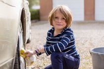 4-річний хлопчик миє машину на парковці — стокове фото