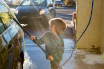 4 year old boy washing a car in car wash — Stock Photo