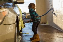4 anno vecchio ragazzo lavaggio un auto in auto lavaggio — Foto stock