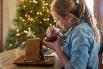11-річна дівчина будує імбирний хлібний будинок вдома — стокове фото