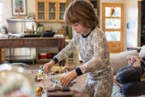 Menino de 4 anos vestindo pijama brincando com brinquedos em casa — Fotografia de Stock