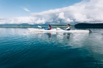 Os kayakers do mar remando águas pristinas de uma entrada na costa de Alaska. — Fotografia de Stock