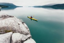 Femmina kayaker mare pagaiare acque incontaminate di Muir Inlet, cielo coperto in lontananza, Glacier Bay National Park, Alaska — Foto stock