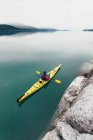 Kayak de mar hembra remando agua prístina de entrada Muir, cielo nublado en la distancia, Parque Nacional Glacier Bay, Alaska - foto de stock