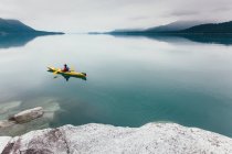 Kayaker do mar fêmea remando água intocada de Muir Inlet, céu nublado na distância, Glacier Bay National Park, Alaska — Fotografia de Stock