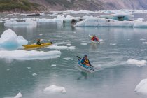 Kayakistes de mer pagayant dans la lagune glaciaire à un terminus glaciaire sur la côte de l'Alaska — Photo de stock