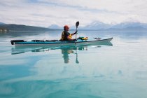 Homme kayak de mer eaux calmes d'une crique dans un parc national. — Photo de stock