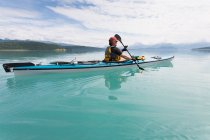 Homme kayak de mer eaux calmes d'une crique dans un parc national. — Photo de stock