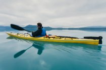 Man sea kayaking inan entrada na costa do Alasca. — Fotografia de Stock