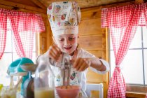 Junges Mädchen in wendy house mit Plastikbesen vorgibt, in Küche zu kochen — Stockfoto