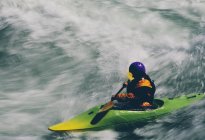Whitewater kayaker paddling large river rapids on a fast flowing river — Stock Photo