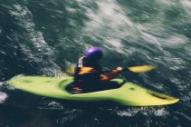 Whitewater kayaker remare grandi rapide fluviali su un fiume che scorre veloce — Foto stock