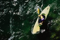 Vista aérea de kayak de aguas bravas remando rápidos en un río que fluye rápido. - foto de stock