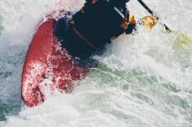 Mulher caiaque caiaque de água branca remando corredeiras e surf em um rio que flui rápido. — Fotografia de Stock