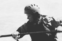 Каякер с белоснежной водой женского пола, гребущие пороги и серфинг на быстротечной реке. — стоковое фото
