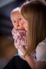 Frau küsst ein kleines Baby auf die Wange — Stockfoto