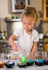 3 year old girl coloring easter eggs at home — Stock Photo