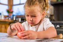 3 year old girl coloring easter eggs at home — Stock Photo