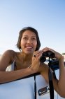 Mulher nativa americana em vestido de sol dirigindo um carro esporte conversível branco olhando através de binóculos — Fotografia de Stock