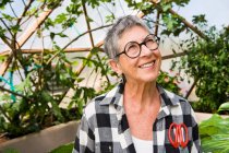 Старша жінка садівництво в геодезичному куполі — стокове фото
