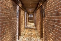 Un hotel con camere in stile retrò vecchio stile, e oggetti rustici, corridoio con tappeto fantasia, porte della camera. — Foto stock