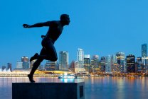 Running Sculpture With a Downtown Background — Stock Photo