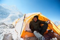 Мужчина сидит в палатке базового лагеря в Гималаях — стоковое фото