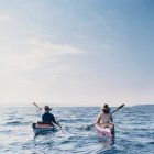 Middle aged man and woman sea kayaking on calm water — Stock Photo