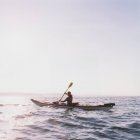 Середнього віку жінка морський байдарка в сутінках, вид збоку — стокове фото