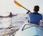 Middle aged man and woman sea kayaking on calm waters — Stock Photo