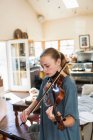 Adolescente jouant son violon à la maison — Photo de stock