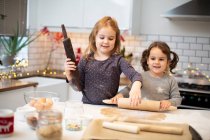 Две девушки стоят на кухне и пекут рождественское печенье.. — стоковое фото
