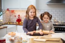 Дві дівчини стоять на кухні, випікають різдвяне печиво . — стокове фото