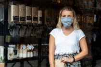Жінка в масці для обличчя покупки в місцевому магазині без відходів — стокове фото